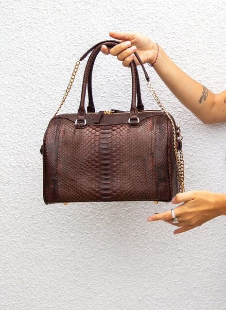 woman holding leather brown bag on white wall back 2025 02 22 11 11 00 utc